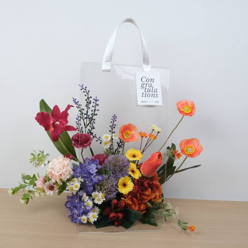 ดอกไม้ประดิษฐ์ผ้าในแจกัน  JGLORYFLOWER  แจกันพลาสติกใส รูปทรงกระเป๋า ดอกไม้คละชนิด สีม่วง/ส้ม_7